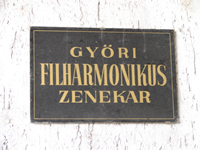 Photo of a plaque identifying the Győr Philharmonic Orchestra (Győri Filharmonikus Zenekar) in an entryway into the orchestra's home, the Janos Richter Hall. Győr, Hungary; (21 September 2007)