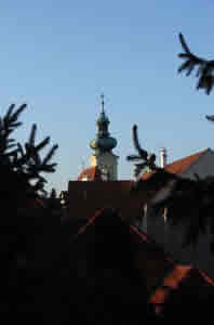 Photo of the Carmelite Church's steeple does not stand as high as that of the Cathedral (Bazilika) atop Chapter Hill (Káptalandomb), yet it is readily seen within the inner town of Győr, as well as from Chapter Hill, as it is seen here. Győr, Hungary (21 September 2007)