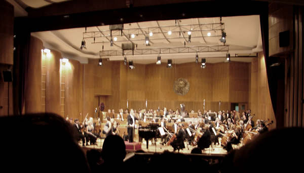 Photo of Katalin Halmai, mezzo-soprano; Mátyás Antal, conductor; the Győr Philharmonic Orchestra acknowledging the audience's applause at the conclusion of the European première of Alma in Győr's János Richter Hall. Győr, Hungary (16 October 2008)