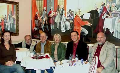 Principals involved in October's recordings and performance, enjoying  pastries at Győr's Mozart Café, upon completion of their work. (L to R) Szidónia Juhász, Mátyás Antal, Harold Schiffman, Jane Perry-Camp, Dávid Zsolt Király, István Biller; W.A. Mozart, at the keyboard. Győr, Hungary (20 October 2008) Photograph by a kind and skilled but unnamed server at the Mozart Café