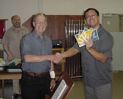 Photo of Dávid Zsolt Király handing Harold the edited and mastered CDs containing the newly recorded Alma (2002), Prelude and Variations for Chamber Orchestra (1970) [recorded in 1998], Chamber Concerto No. 2: In Memoriam Edward Kilenyi (2000) with recording engineer István Biller looking on, Győr, Hungary (17 June 2007)