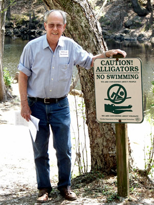 Harold Schiffman, strolling along the Santa Fe River bank, likewise cheerfully obeys this sign:  "CAUTION!  ALLIGATORS -- NO SWIMMING." Suwannee Banjo Camp, O'Leno State Park, Florida (20 March 2009)