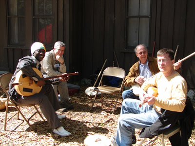 "African Roots," one of the Suwannee Banjo Camp's course sequences, offers ekonting classes such as this one.  (L to R) Sana Ndiaye (SBC faculty member, with his large ekonting), SBC faculty member Greg Adams, student and enthusiast Harold Schiffman, SBC faculty member Paul Sedgwick. Suwannee Banjo Camp, O'Leno State Park, Florida (21 March 2009)